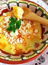 Krina Maismehl für Kachamak - Maismehl Rezept | 500g, Bulgarien: Traditioneller Kachamak mit zerbröseltem Käse, Paprikaöl und Petersilie in Keramikschale serviert.