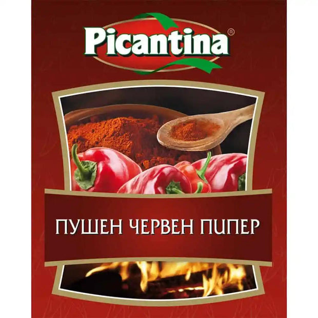 Picantina Smoked Paprika 30g - Authentic Bulgarian Spices mit Holzlöffel, Paprikapulver und frischen roten Paprikaschoten auf rotem Hintergrund.