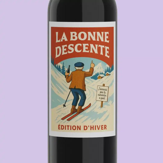 Detailansicht des Etiketts vom Rotwein The Good Descent Bordeaux, zeigt Skifahrer in verschneiter Winterlandschaft mit humorvollem Schild.